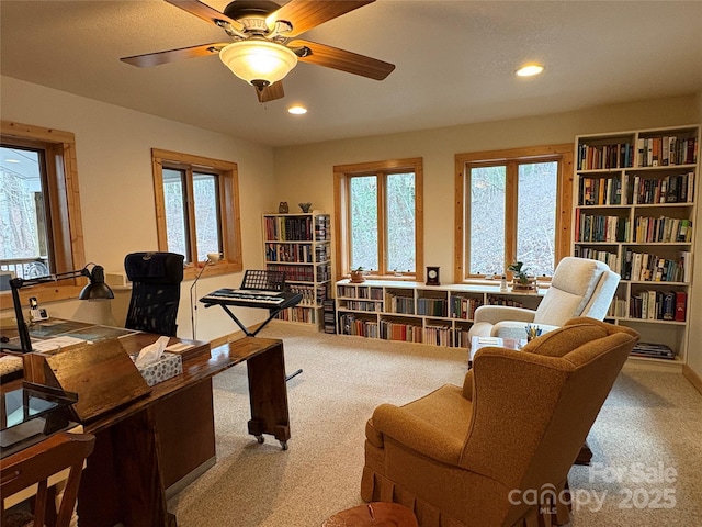 carpeted office space featuring ceiling fan