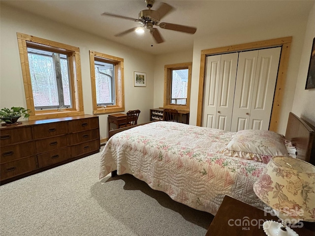 bedroom with multiple windows, carpet, ceiling fan, and a closet