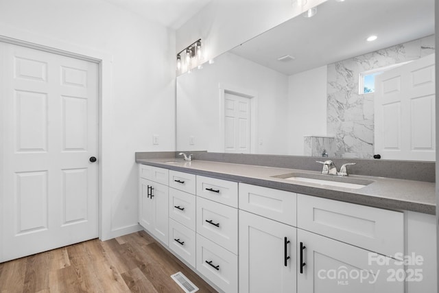 bathroom with vanity, hardwood / wood-style floors, and a tile shower