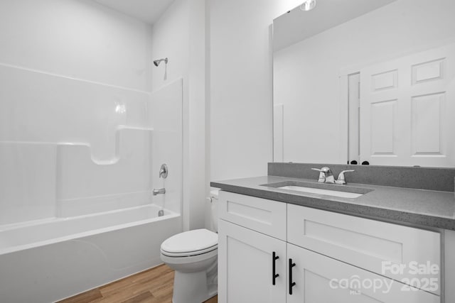 full bathroom featuring vanity, hardwood / wood-style flooring, bathtub / shower combination, and toilet