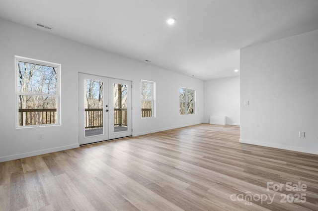 unfurnished living room featuring light wood-type flooring and french doors