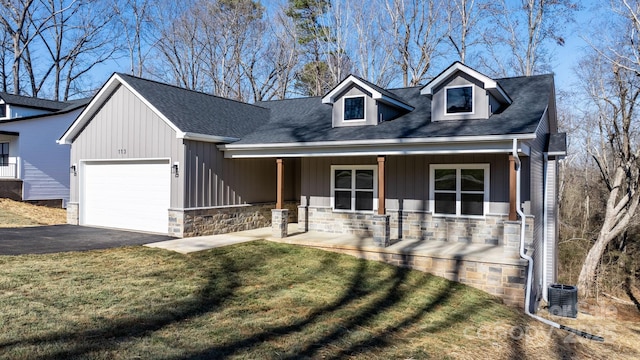 cape cod house with a garage, central AC, covered porch, and a front lawn