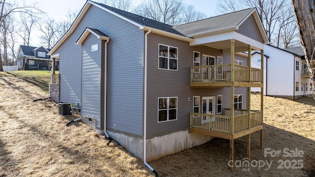 rear view of house featuring a balcony, central AC unit, and a deck