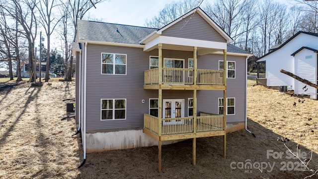 rear view of house with a wooden deck, central AC unit, and a balcony