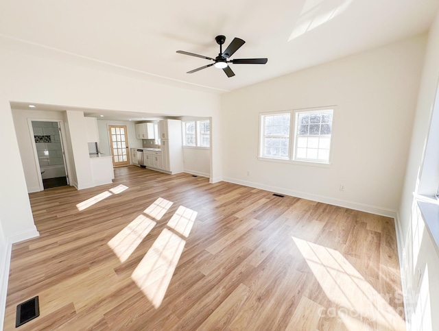 unfurnished living room with baseboards, visible vents, a ceiling fan, and light wood finished floors
