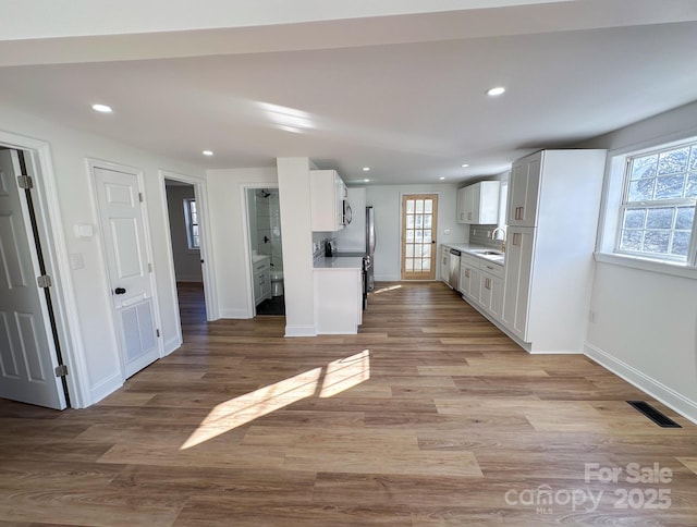 kitchen featuring appliances with stainless steel finishes, visible vents, a sink, and a healthy amount of sunlight