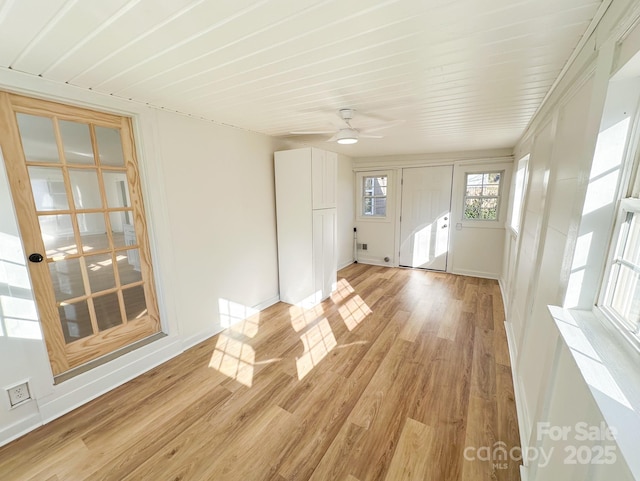 interior space featuring a ceiling fan, baseboards, and light wood-style floors