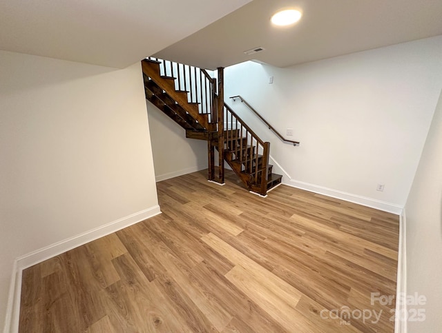interior space with baseboards, stairway, visible vents, and light wood-style floors