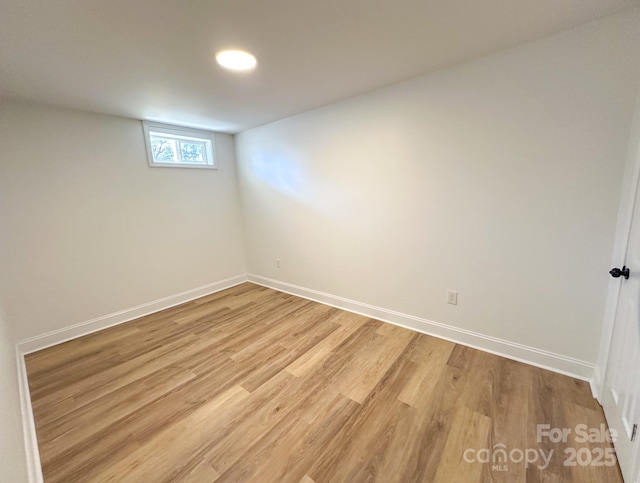 spare room featuring light wood finished floors and baseboards