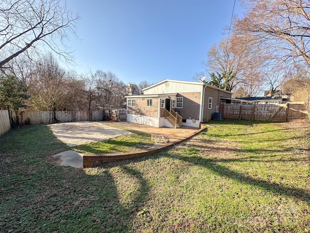 view of yard with a fenced backyard, entry steps, a patio area, and central AC unit