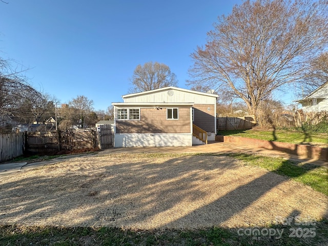 rear view of property with a gate, fence, and entry steps