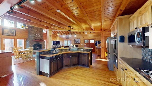 kitchen with gas stovetop, wood ceiling, track lighting, wooden walls, and beamed ceiling