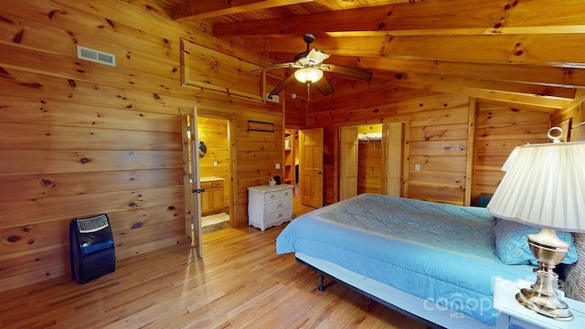 bedroom with wooden walls, vaulted ceiling with beams, ceiling fan, wood ceiling, and light hardwood / wood-style floors