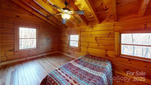 unfurnished bedroom featuring wood ceiling, ceiling fan, lofted ceiling with beams, and wood walls