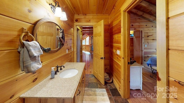 bathroom featuring vanity, wood ceiling, and wood walls