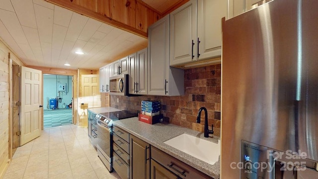 kitchen featuring stainless steel appliances, sink, gray cabinetry, and backsplash