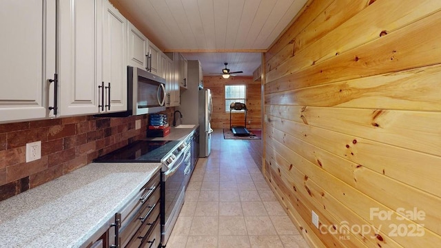 714 Heartwood Dr, Marion, NC 28752 - kitchen with stainless steel appliances, wood walls, tasteful backsplash, white cabinetry, and a sink