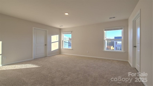 empty room featuring light carpet and plenty of natural light