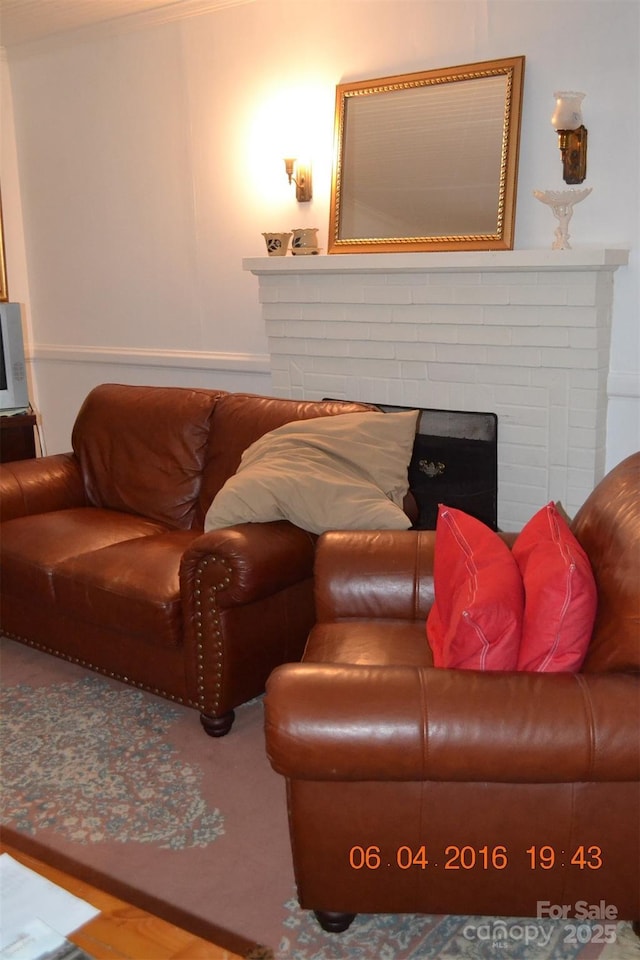 living area featuring a brick fireplace