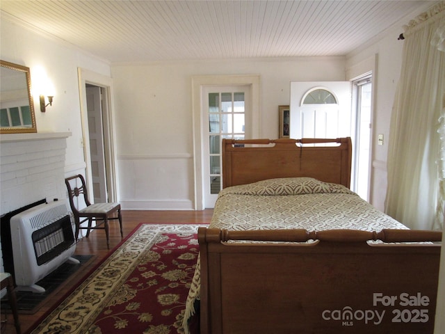 bedroom with heating unit, wooden ceiling, wood finished floors, and ornamental molding