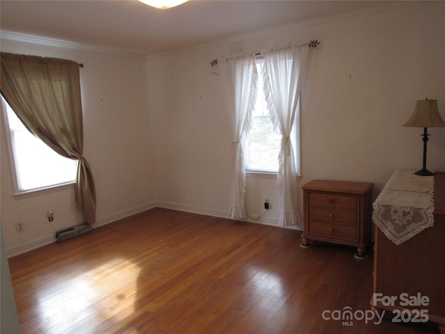 unfurnished bedroom featuring baseboards, wood finished floors, and crown molding