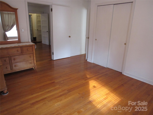 unfurnished bedroom with a closet and wood finished floors
