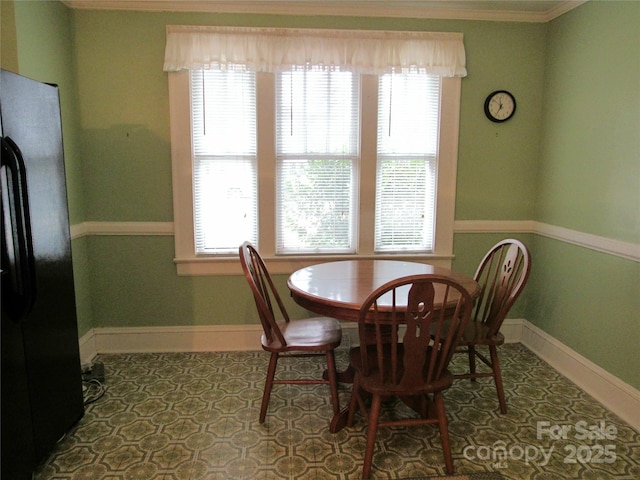 dining space with tile patterned flooring, crown molding, baseboards, and a wealth of natural light