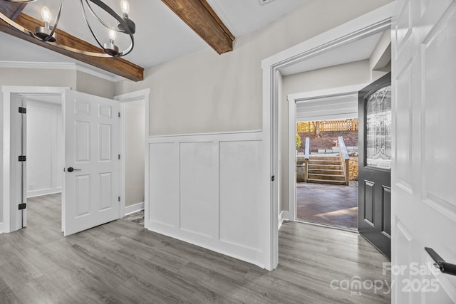 dining area featuring hardwood / wood-style flooring, beam ceiling, and a chandelier