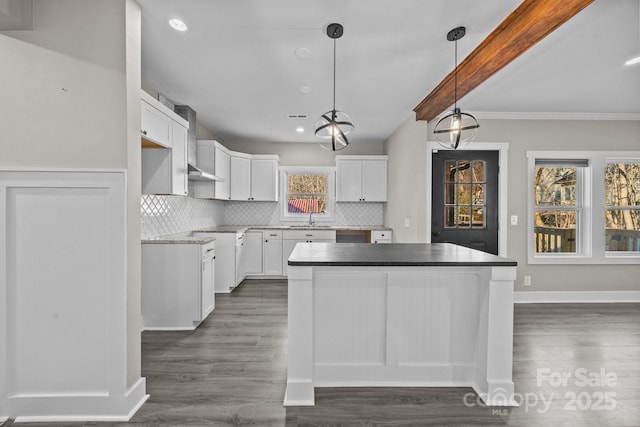 kitchen featuring sink, tasteful backsplash, dark hardwood / wood-style flooring, pendant lighting, and white cabinets