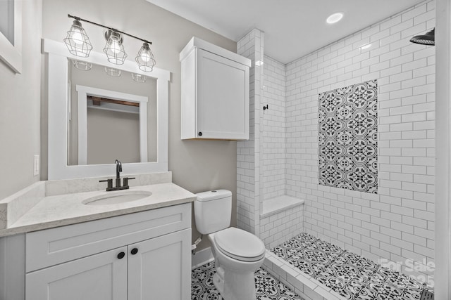 bathroom featuring vanity, toilet, and a tile shower