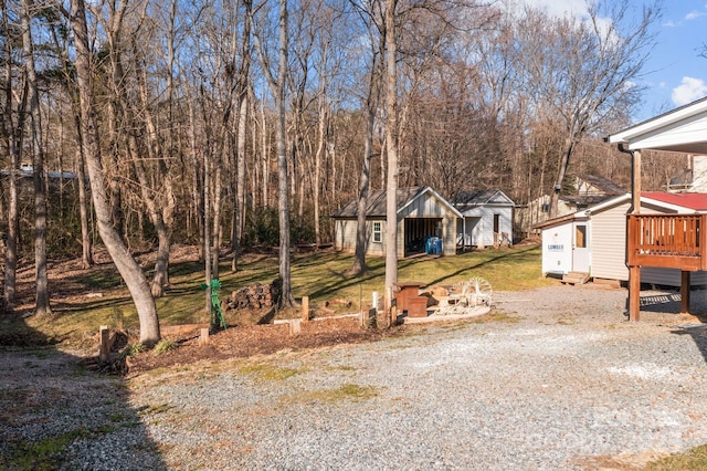 view of yard featuring a wooden deck and an outbuilding