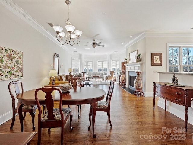 dining area with crown molding, ceiling fan with notable chandelier, and hardwood / wood-style floors