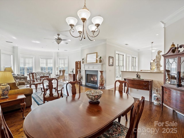 dining room featuring ornamental molding, dark hardwood / wood-style flooring, and ceiling fan with notable chandelier