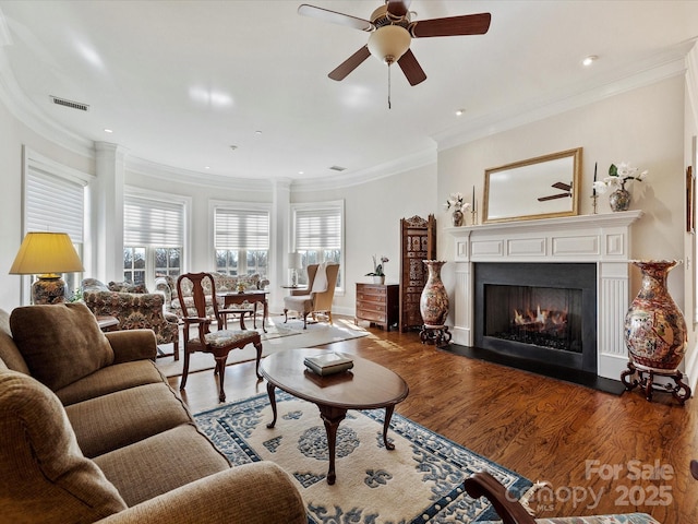 living room with ceiling fan, ornamental molding, and dark hardwood / wood-style floors