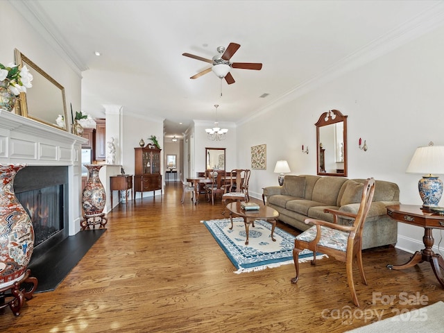 living room with crown molding, hardwood / wood-style flooring, and ceiling fan with notable chandelier