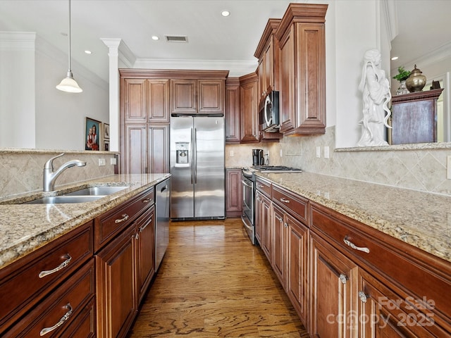 kitchen featuring decorative light fixtures, sink, stainless steel appliances, crown molding, and light stone countertops