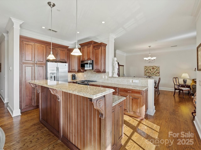 kitchen with pendant lighting, a kitchen island, kitchen peninsula, and appliances with stainless steel finishes