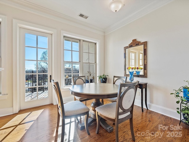 dining room featuring hardwood / wood-style floors and crown molding