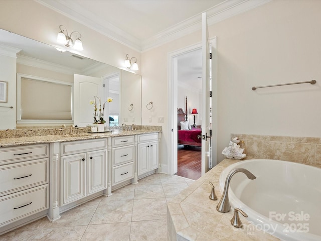 bathroom featuring tile patterned flooring, crown molding, tiled bath, and vanity