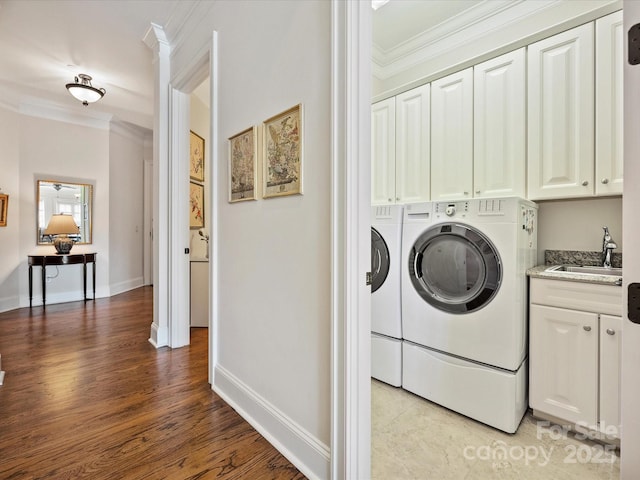 laundry room with washer and dryer, sink, cabinets, crown molding, and light wood-type flooring