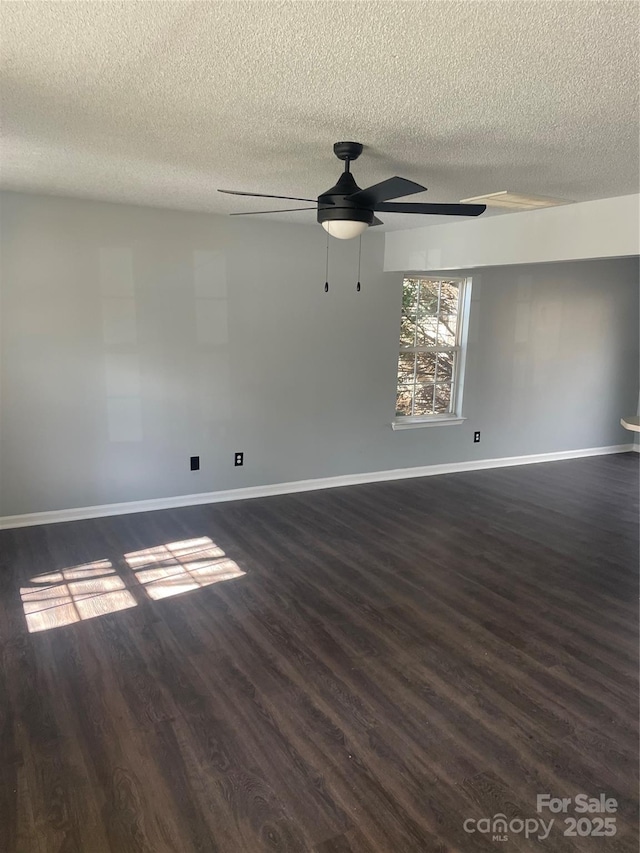 spare room with dark wood-style floors, a textured ceiling, baseboards, and a ceiling fan