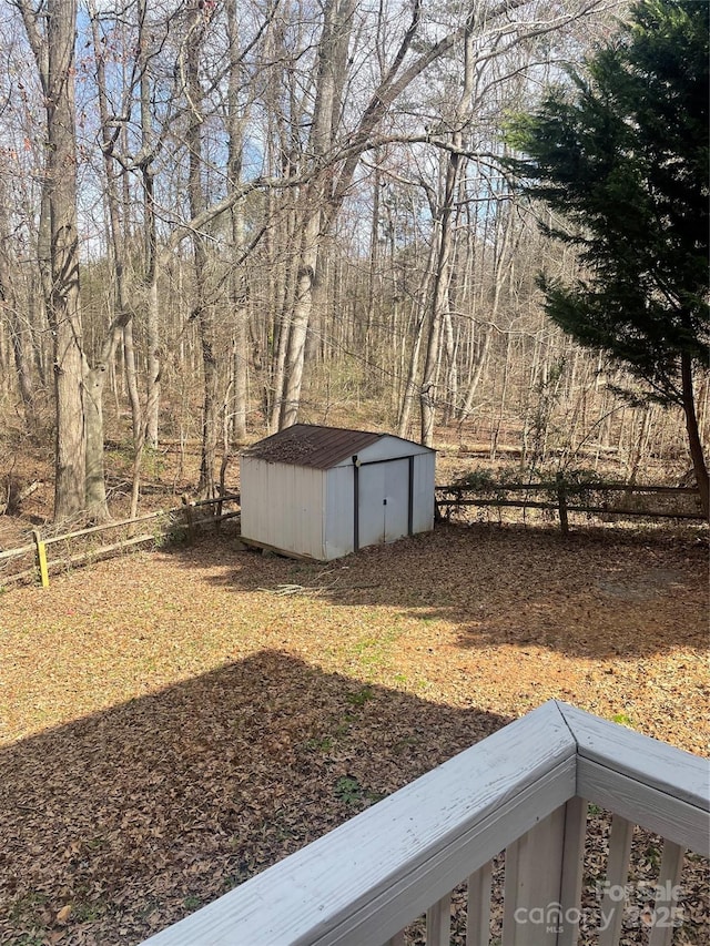 view of yard featuring a storage shed, fence, and an outbuilding