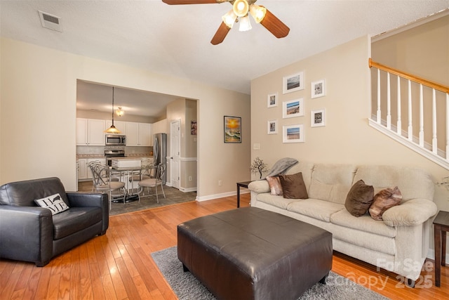 living room featuring hardwood / wood-style floors and ceiling fan