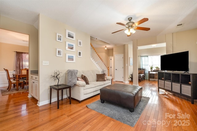 living room with ceiling fan and light hardwood / wood-style flooring