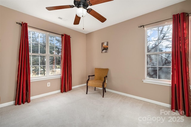 living area with light colored carpet and ceiling fan