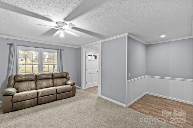 living room featuring crown molding, wood-type flooring, a textured ceiling, and ceiling fan