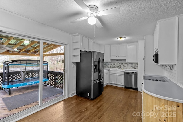 kitchen with white cabinetry, a textured ceiling, appliances with stainless steel finishes, dark hardwood / wood-style floors, and backsplash