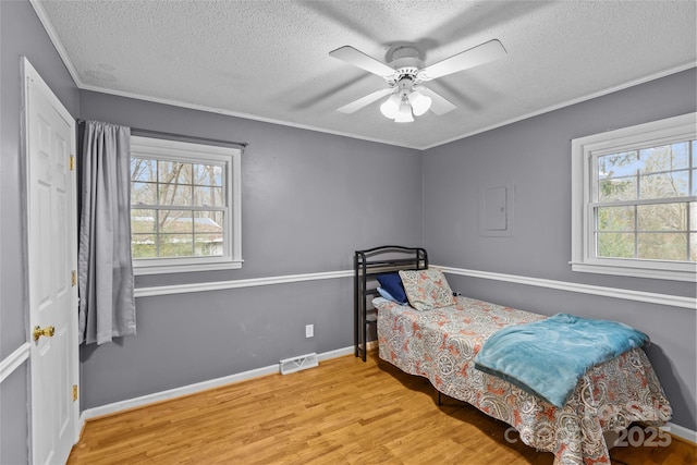 bedroom featuring crown molding, ceiling fan, a textured ceiling, and light wood-type flooring