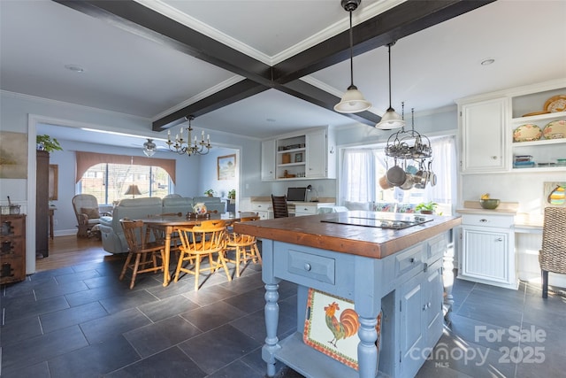 kitchen with white cabinetry, pendant lighting, wooden counters, and beamed ceiling