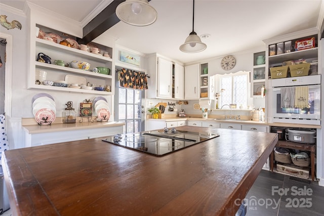 kitchen featuring white cabinetry, oven, wooden counters, hanging light fixtures, and black electric stovetop